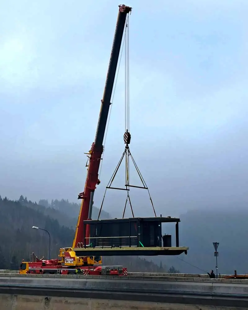 Kran hebt das Saunaboot zum See