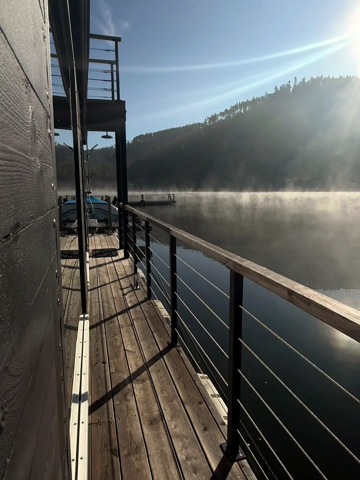 The SaaleSpa wooden deck in the first sunlight over the misty lake