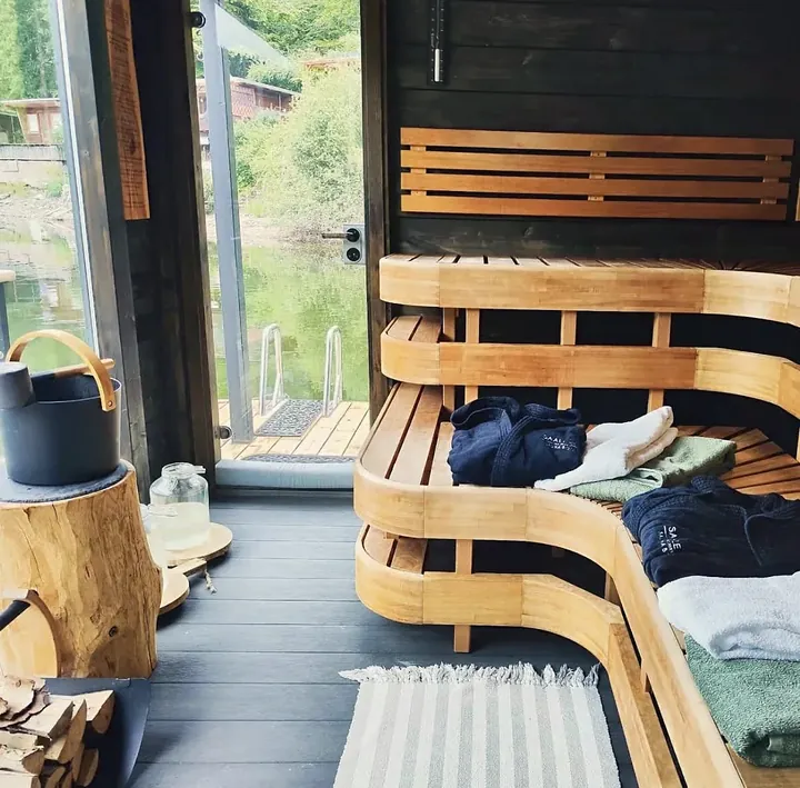 Die Holzsauna des SaaleSpa mit geschwungenen Bänken und Panoramafenster