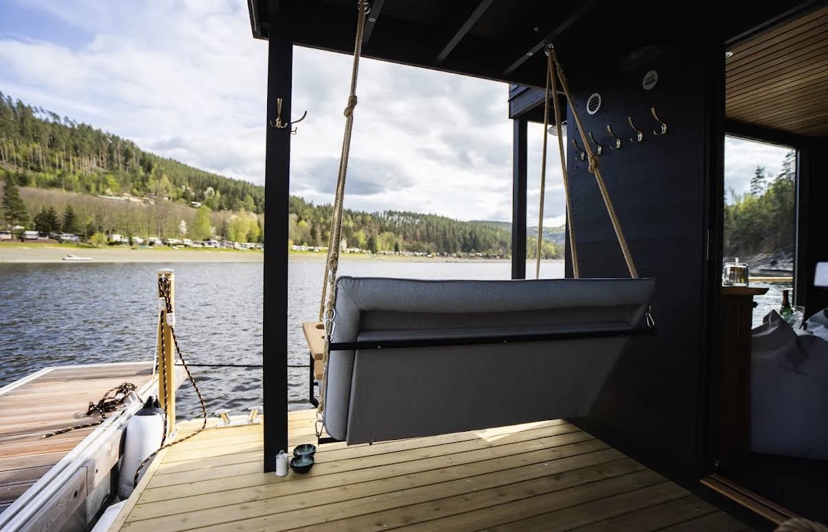 Original photograph of the lower outdoor deck with its hanging lounge and lake view.